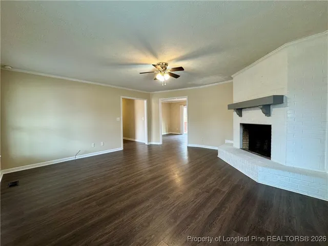 an empty room with wooden floor and a fireplace
