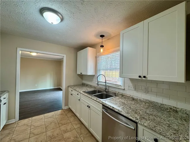 a kitchen with granite countertop a sink and a stove