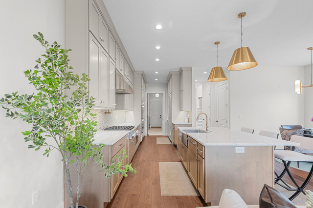 250 South Main Street, Unit 24 Alpine, UT 84004 - Photo 7 of 50 Kitchen featuring light stone countertops, a breakfast bar area, light wood-style floors, a spacious island, and tasteful backsplash