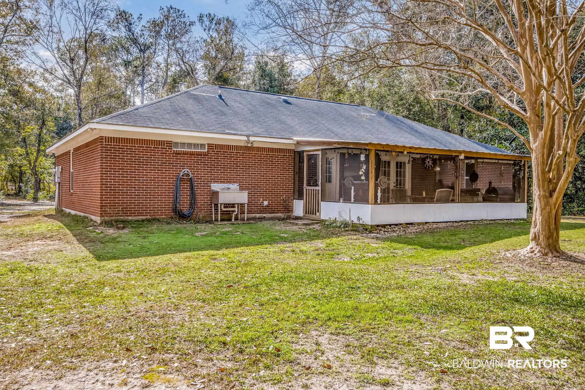 12199 Bay Road West Foley, AL 36535 - Photo 48 of 62 Rear view of property with a sunroom, a yard, brick siding, and a shingled roof