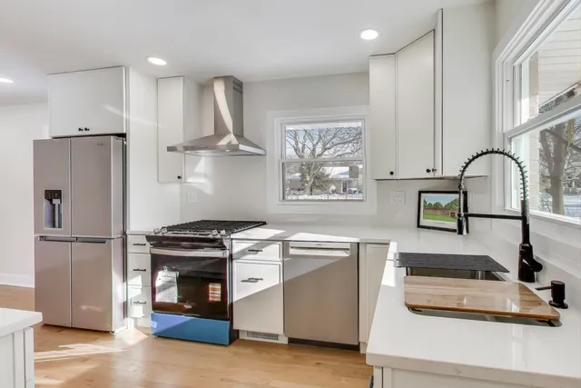 a kitchen with stainless steel appliances granite countertop a sink stove and refrigerator