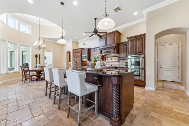a living room with furniture kitchen view and a large window