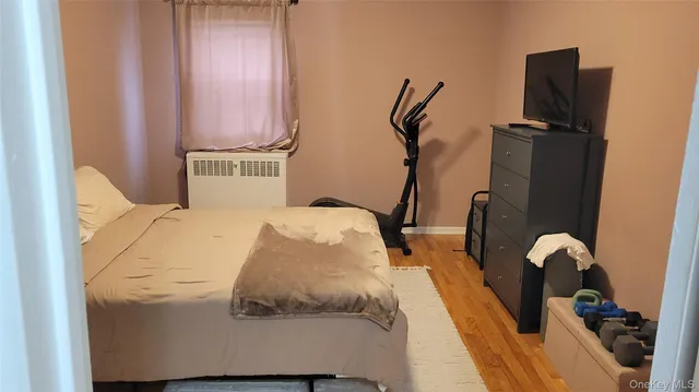 a bedroom with bed and wooden floor