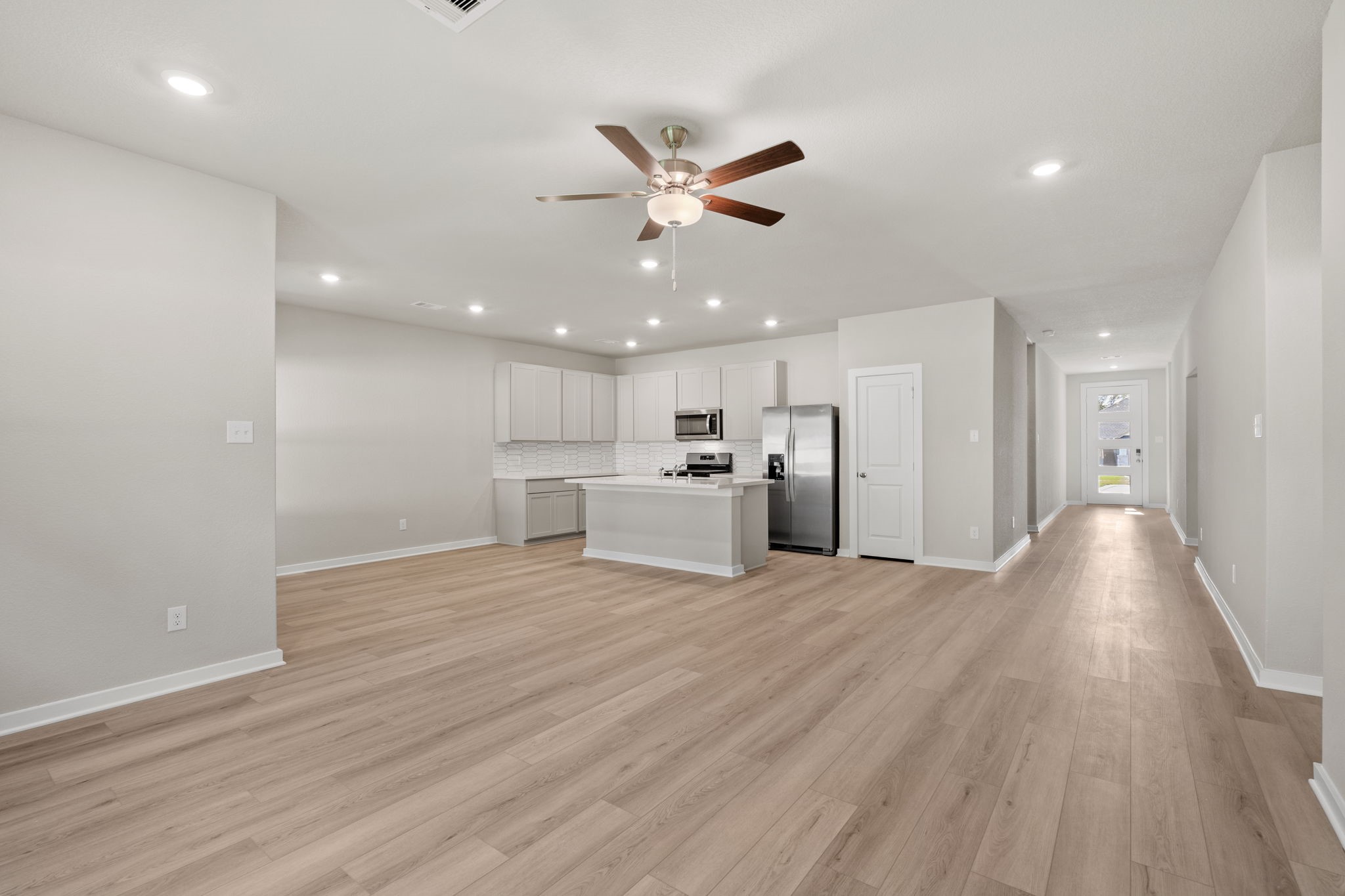 12343 Ridge Top Drive Conroe, TX 77304 - Photo 12 of 32 a view of an empty room with wooden floor and a ceiling fan