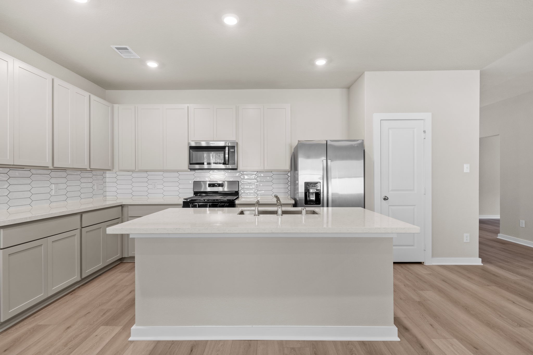 12343 Ridge Top Drive Conroe, TX 77304 - Photo 3 of 32 a kitchen with kitchen island sink stove and cabinets
