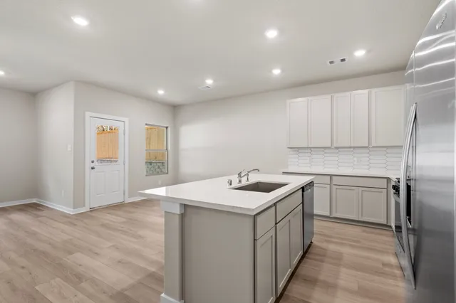 a kitchen with a sink stove and refrigerator