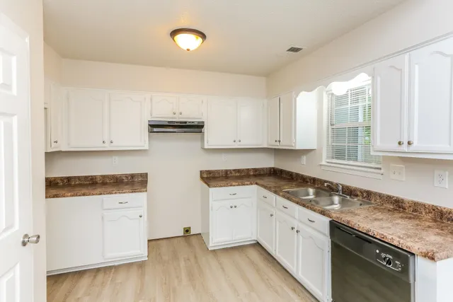 a kitchen with granite countertop white cabinets and white appliances