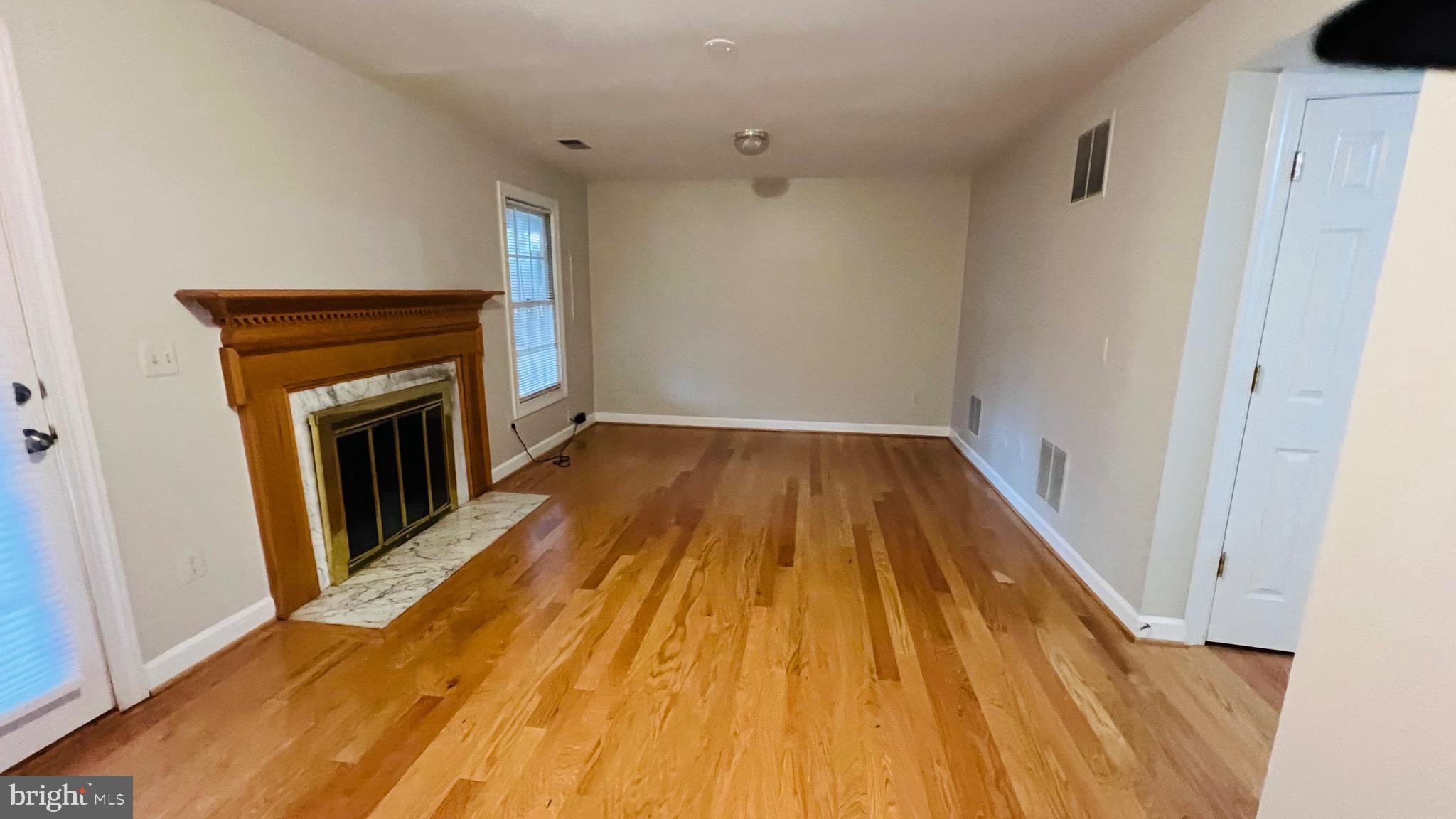 8035 Trevor Place Vienna, VA 22182 - Photo 12 of 48 a view of a livingroom with wooden floor and a fireplace