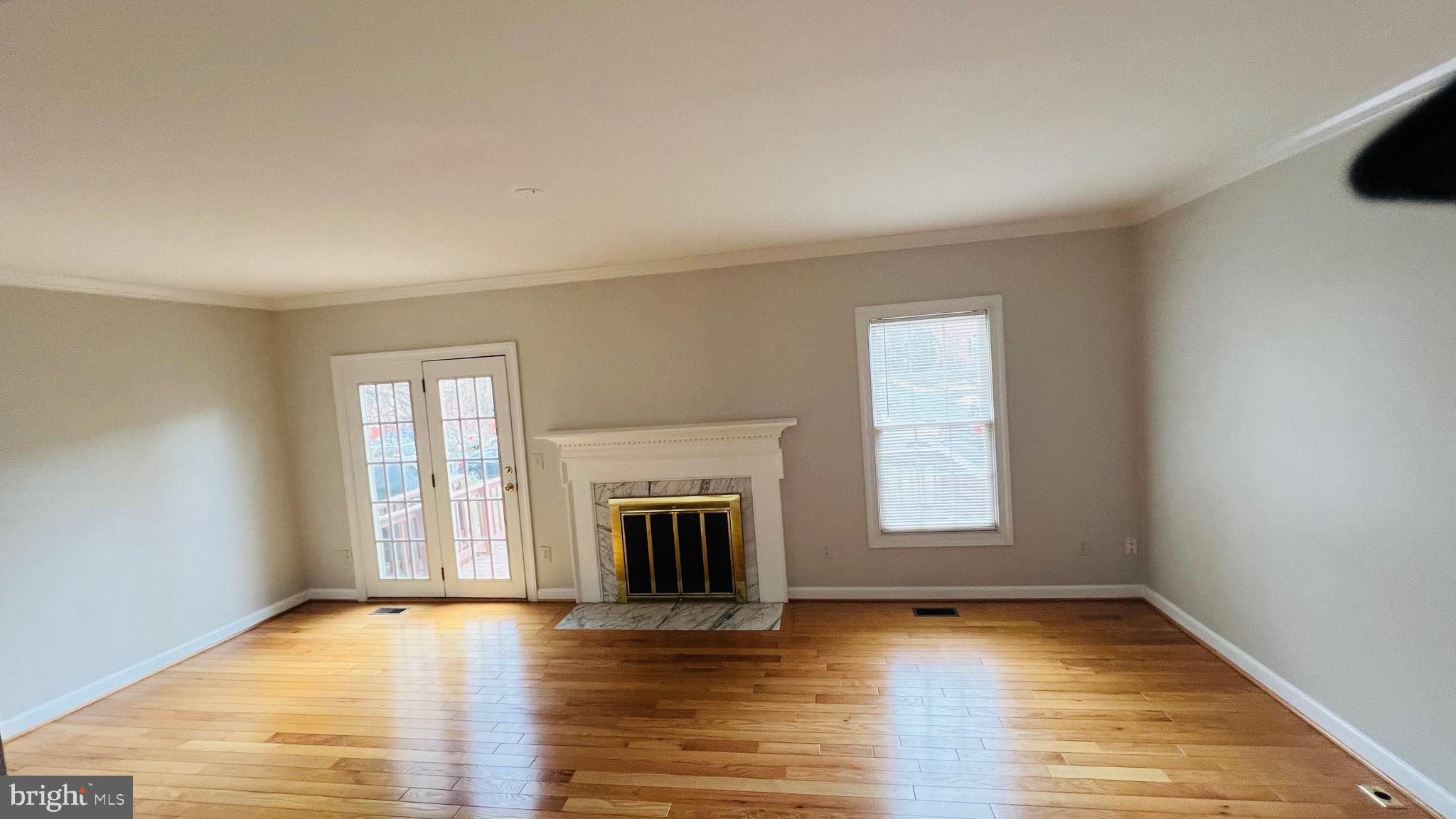8035 Trevor Place Vienna, VA 22182 - Photo 27 of 48 an empty room with wooden floor fireplace and windows