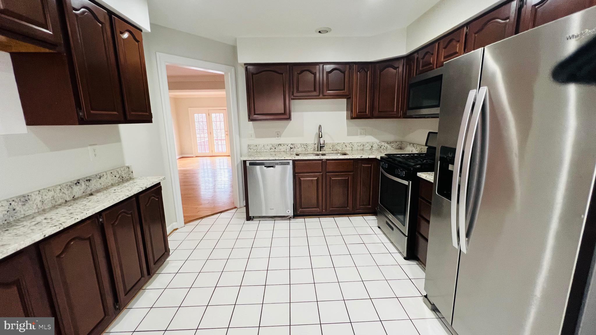 8035 Trevor Place Vienna, VA 22182 - Photo 33 of 48 a kitchen with stainless steel appliances granite countertop a refrigerator stove a sink and dishwasher