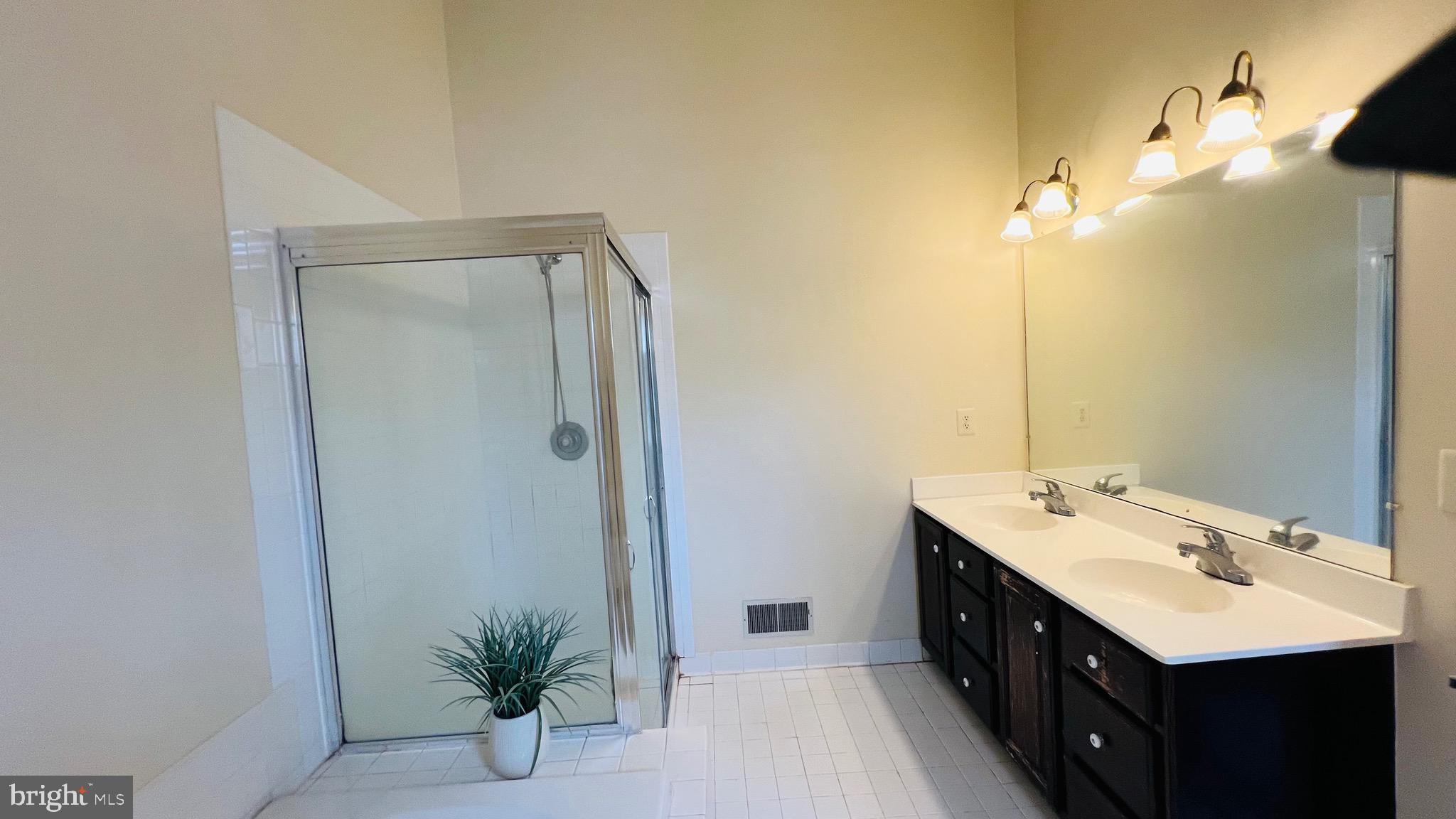 8035 Trevor Place Vienna, VA 22182 - Photo 47 of 48 a spacious bathroom with a double vanity sink and a mirror