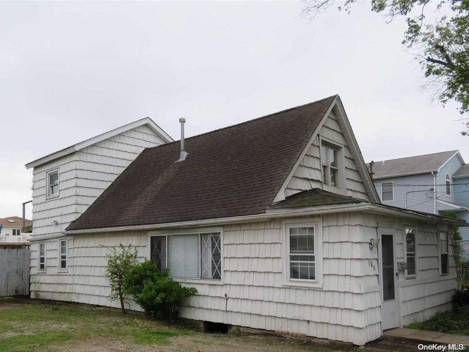 Undisclosed Address Freeport, NY 11520 - Photo 1 of 1 a front view of a house with a yard