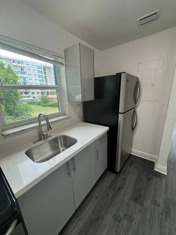 a kitchen with a refrigerator and a sink