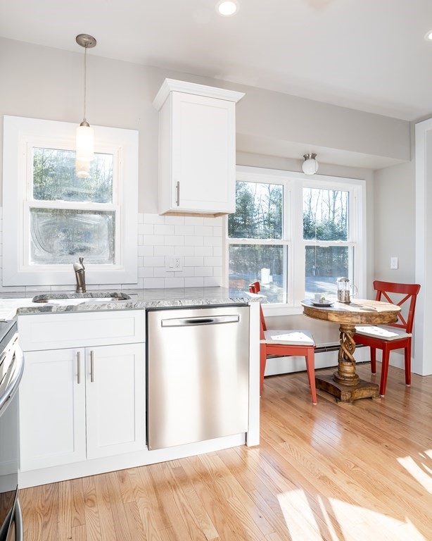 252 Old Warren Road Palmer, MA 01069 - Photo 6 of 29 a kitchen with stainless steel appliances granite countertop a stove a sink a refrigerator and a dining table with wooden floor
