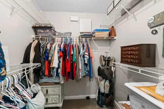 a view of walk in closet with clothes