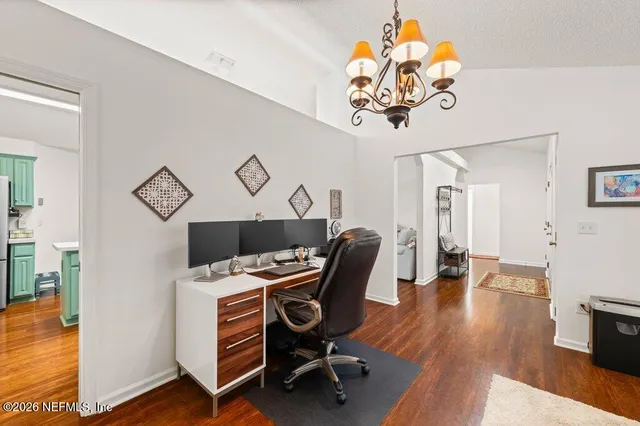 a view of a workspace with furniture and wooden floor