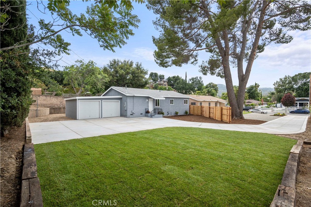 a view of a white house with a big yard
