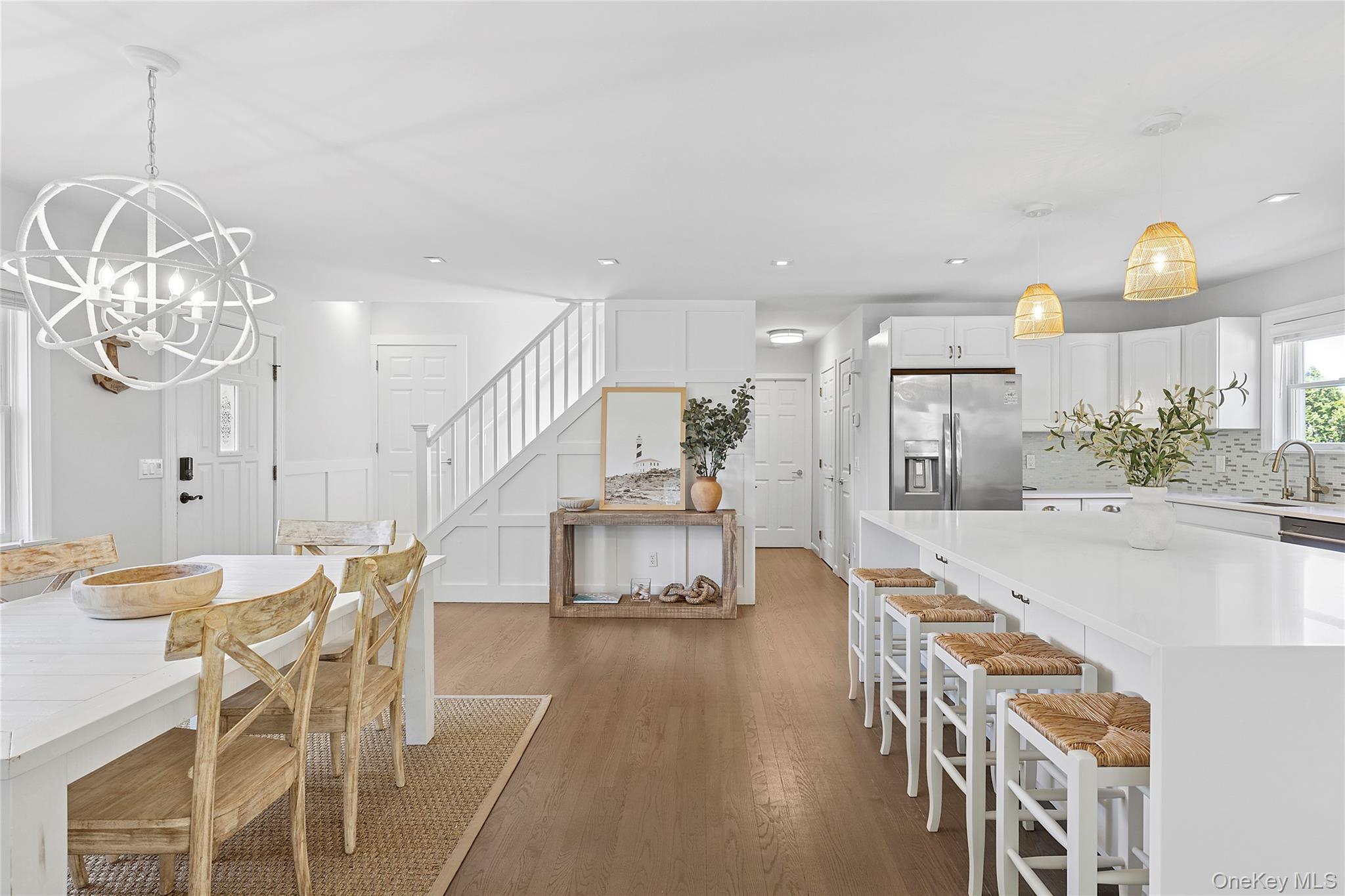 31 Highland Road Southampton, NY 11968 - Photo 4 of 19 Dining room with a decorative wall, stairs, dark wood finished floors, and a chandelier