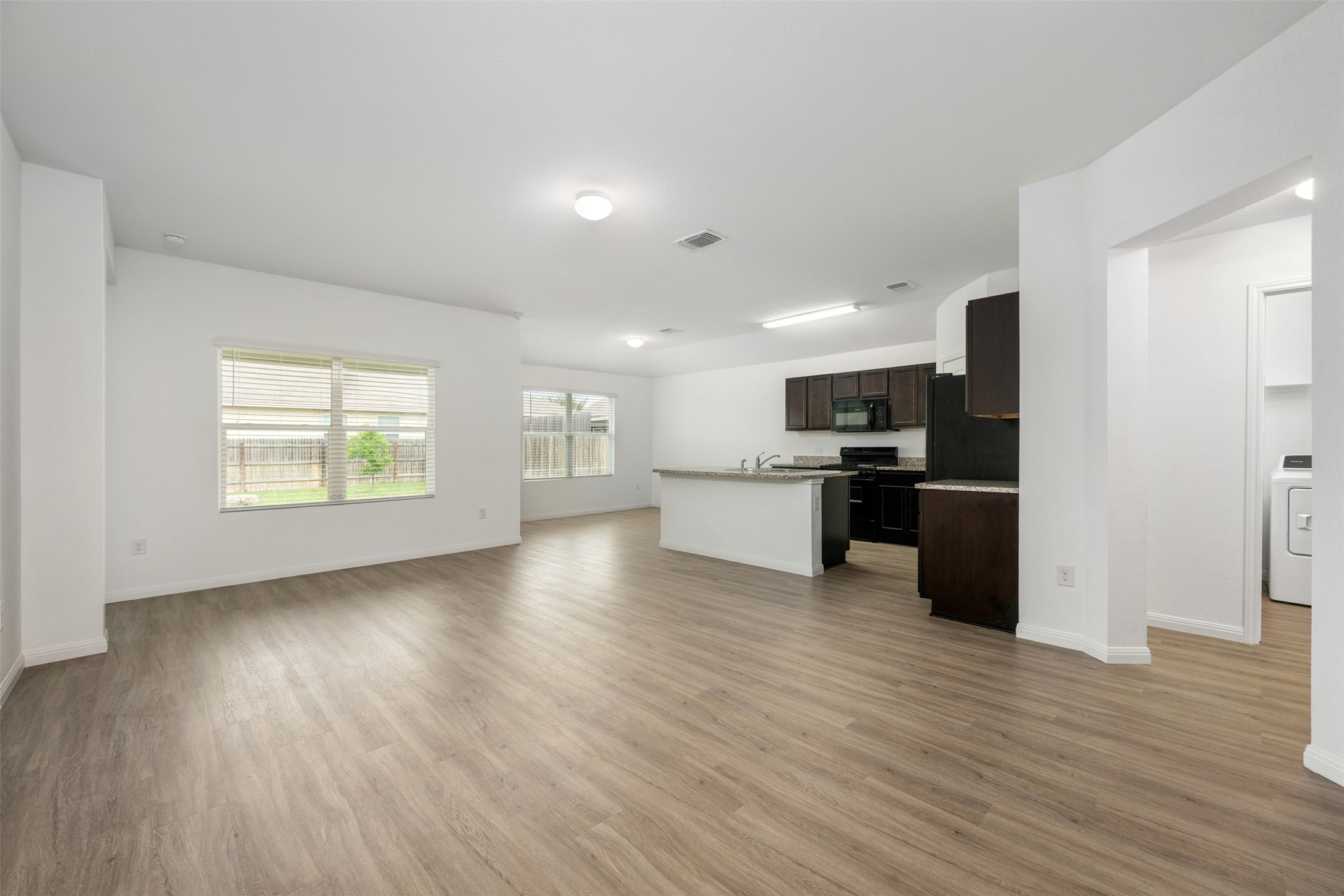 14900 Retha Pass Austin, TX 78725 - Photo 8 of 39 Spacious open-concept living area featuring wood-finish flooring, recessed lighting, and multiple windows