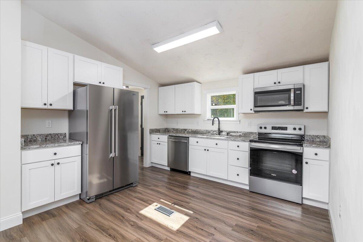 36 Nutmeg Lane Penhook, VA 24137 - Photo 9 of 37 a kitchen with granite countertop a refrigerator stove and wooden floor