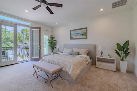 a spacious bedroom that has a bed and a potted plant