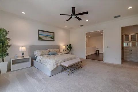 a spacious bedroom with a bed and a chandelier
