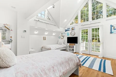 a bedroom with a bed window and a flat screen tv