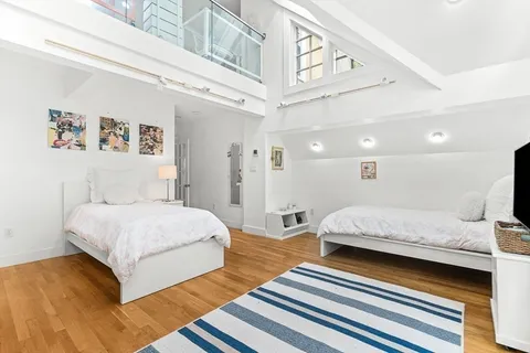 a spacious bedroom with a bed and a chandelier