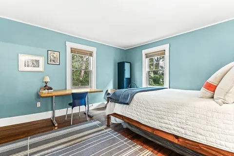 a bedroom with a bed a table and a window