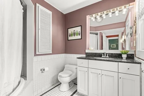 a bathroom with a granite countertop sink toilet a mirror and a shower