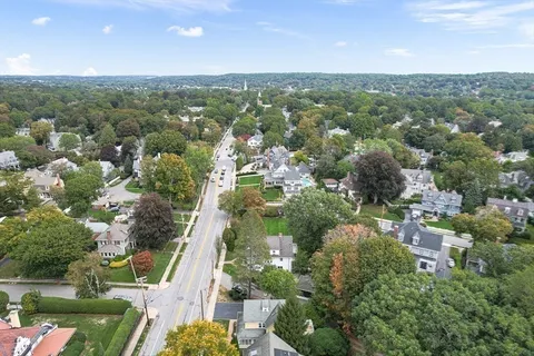 an aerial view of residential houses with outdoor space and trees