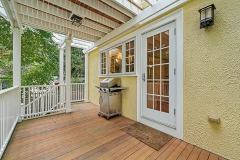 a view of a balcony with wooden floor and iron gate