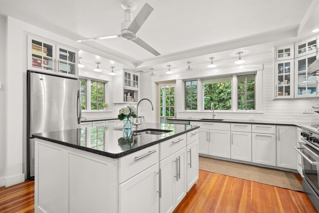 104 Church Street Winchester, MA 01890 - Photo 8 of 42 a kitchen with stainless steel appliances granite countertop a refrigerator a sink dishwasher a stove and white countertops with wooden floor
