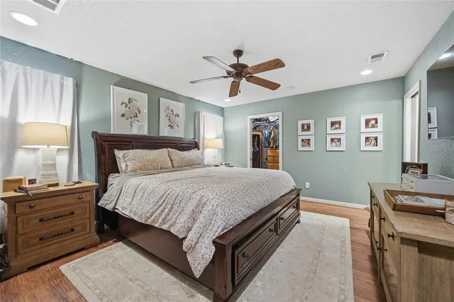 a spacious bedroom with a bed and a dresser