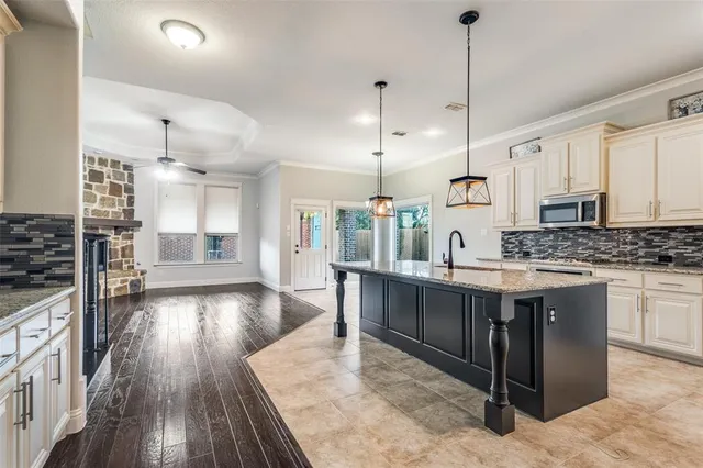 a large kitchen with kitchen island a island a sink a stove and wooden floor