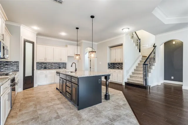 a kitchen with wooden floor and white cabinets