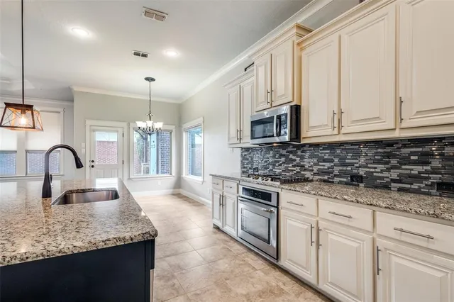 a kitchen with sink a stove and cabinets