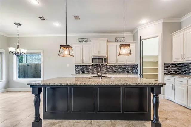 a kitchen with kitchen island granite countertop a stove a sink a refrigerator and wooden cabinets