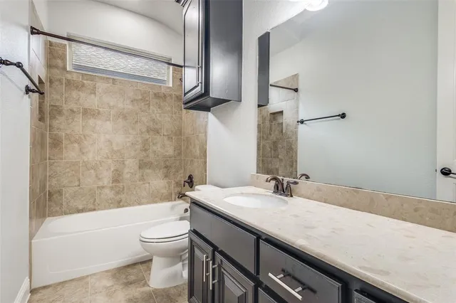 a bathroom with a granite countertop sink a toilet and shower