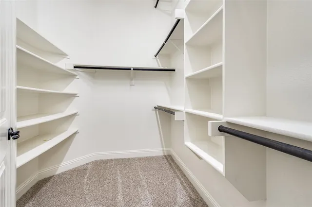 a view of walk in closet with empty racks