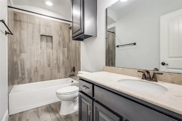 a bathroom with a sink a toilet and a large mirror