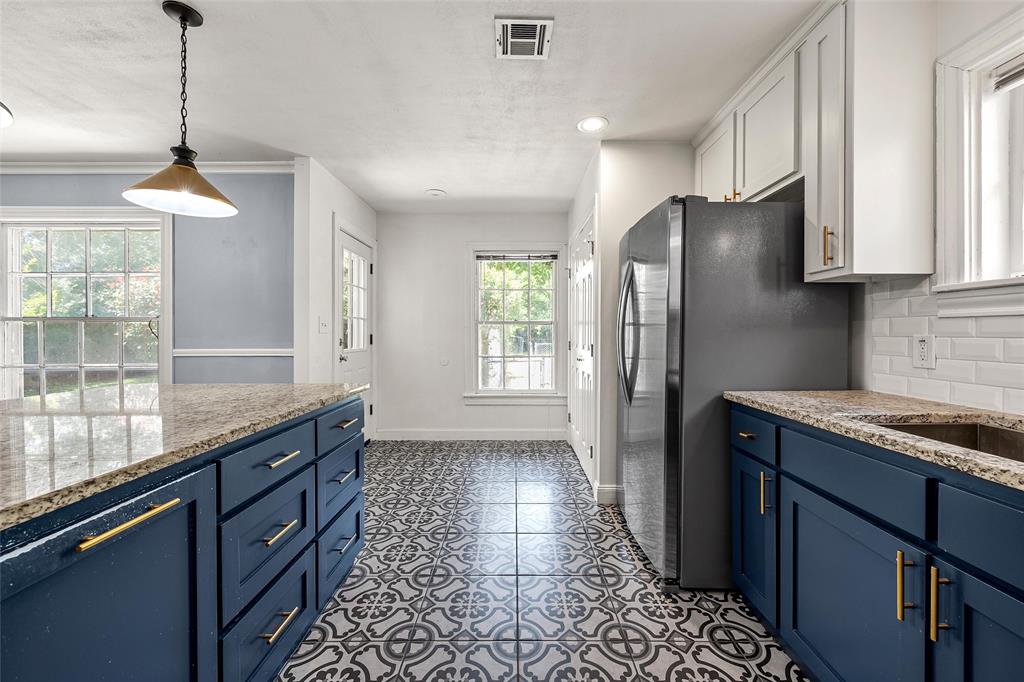 3225 Windsor Avenue Waco, TX 76708 - Photo 10 of 25 Kitchen featuring patterned floor tile, blue base cabinetry, white upper cabinetry, stone-finish countertops, and subway tile backsplash