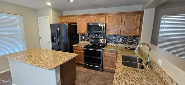 a bedroom with a granite countertop sink and chandelier
