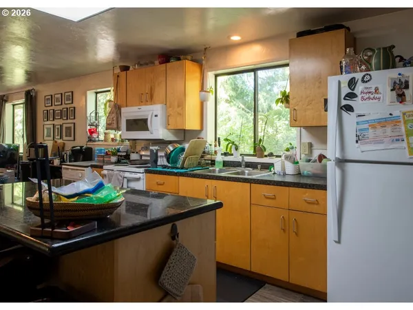 a kitchen with stainless steel appliances granite countertop a sink a stove and a refrigerator