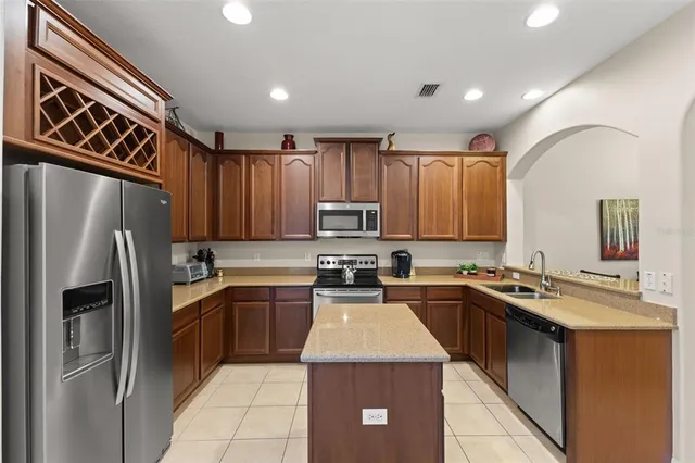 a kitchen with a sink a refrigerator and cabinets