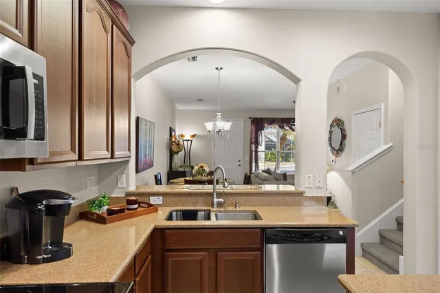 a kitchen with sink a refrigerator and chairs