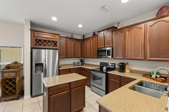 a kitchen with stainless steel appliances granite countertop a refrigerator stove and sink
