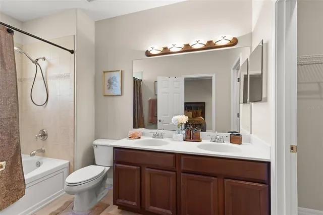 a bathroom with a toilet a sink a tub and mirror