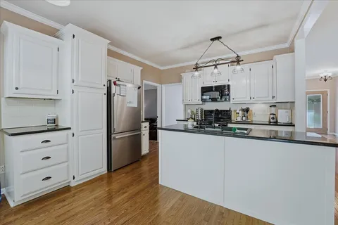 a kitchen with granite countertop a refrigerator a stove a microwave and cabinets