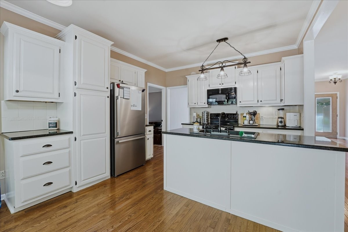 104 Kemper Court Springfield, TN 37172 - Photo 11 of 40 a kitchen with granite countertop a refrigerator a stove a microwave and cabinets